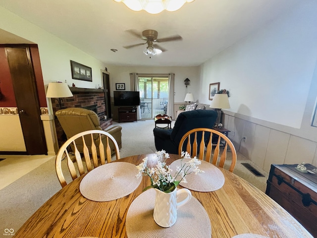 1008 Whispering Trl, Greenfield, IN 46140 - dining area with carpet, a fireplace, a wainscoted wall, and ceiling fan