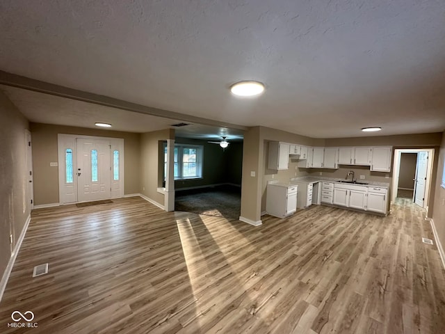 2951 S Elizabeth St, Indianapolis, IN 46203 - kitchen featuring open floor plan, light wood finished floors, white cabinetry, and light countertops