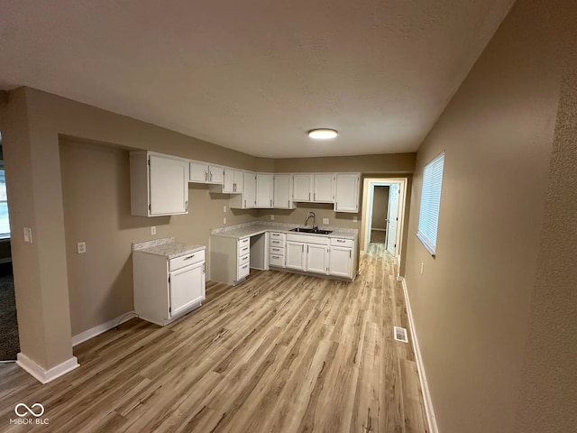 2951 S Elizabeth St, Indianapolis, IN 46203 - kitchen featuring light wood-type flooring, light countertops, and white cabinetry