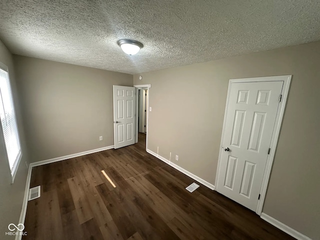 5704 N Keystone Ave, Indianapolis, IN 46220 - unfurnished bedroom featuring dark wood finished floors and a textured ceiling
