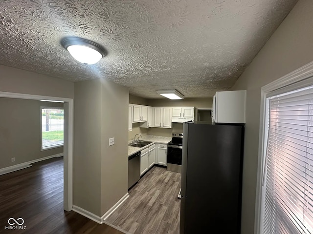 5704 N Keystone Ave, Indianapolis, IN 46220 - kitchen with stainless steel appliances, a textured ceiling, dark wood-style floors, white cabinets, and light countertops