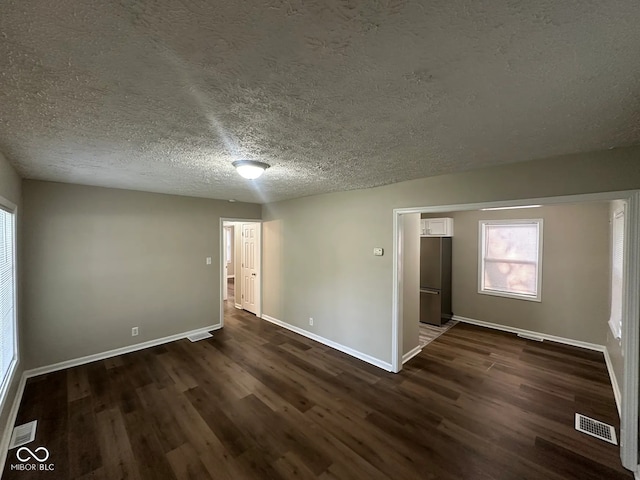 5704 N Keystone Ave, Indianapolis, IN 46220 - empty room featuring dark wood-style flooring and a textured ceiling