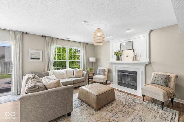 12259 Sweet Creek Trl, Fishers, IN 46037 - living area featuring a fireplace with flush hearth, wood finished floors, and a textured ceiling
