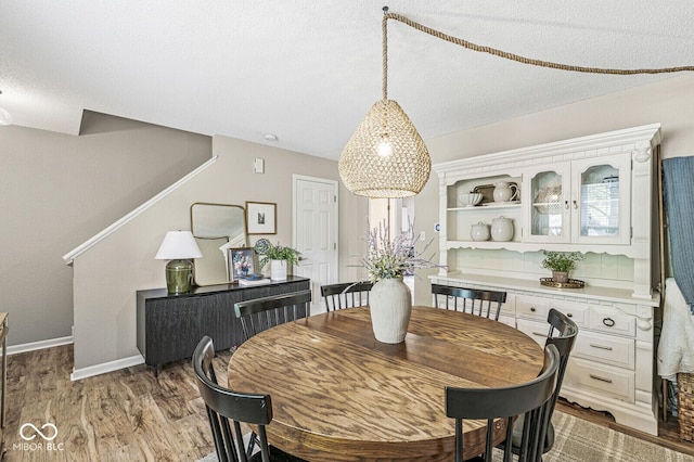 12259 Sweet Creek Trl, Fishers, IN 46037 - dining area with light wood-style floors, a textured ceiling, and stairway