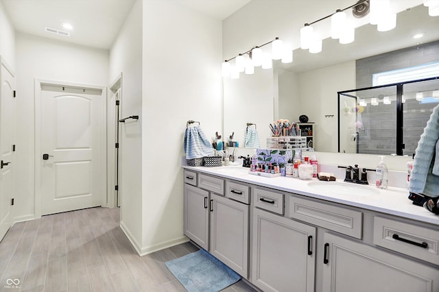 2612 Ruffian Dr, Westfield, IN 46074 - bathroom featuring double vanity, a stall shower, wood finished floors, and recessed lighting