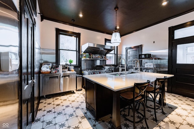 825 E Washington St, Muncie, IN 47305 - kitchen featuring light floors, exhaust hood, light countertops, an island with sink, and pendant lighting