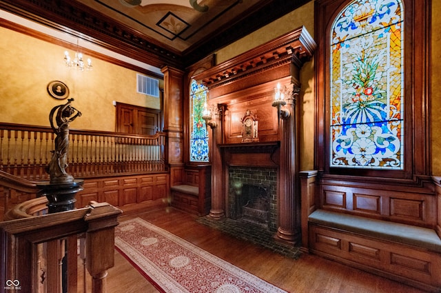 825 E Washington St, Muncie, IN 47305 - sitting room featuring wood finished floors, crown molding, a fireplace with flush hearth, and a decorative wall