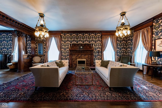 825 E Washington St, Muncie, IN 47305 - living room featuring a chandelier, crown molding, wood finished floors, and a brick fireplace