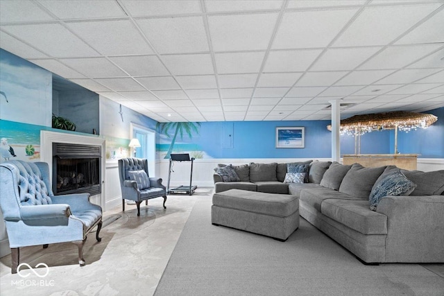 6975 Milhouse Rd, Indianapolis, IN 46221 - living room featuring concrete flooring, a paneled ceiling, and a fireplace