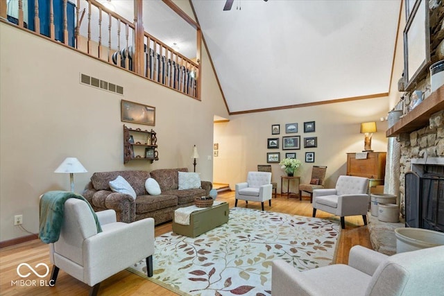 6975 Milhouse Rd, Indianapolis, IN 46221 - living area featuring a towering ceiling, light wood-type flooring, a fireplace, and ceiling fan