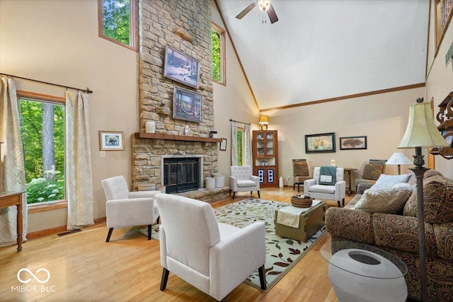 6975 Milhouse Rd, Indianapolis, IN 46221 - living room featuring high vaulted ceiling, a stone fireplace, a ceiling fan, and wood finished floors