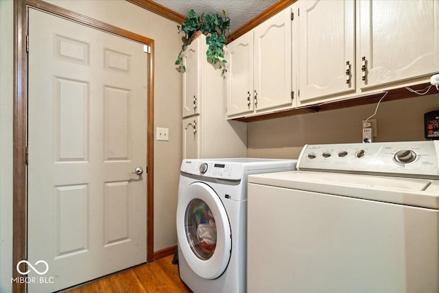 6975 Milhouse Rd, Indianapolis, IN 46221 - laundry area with cabinet space, independent washer and dryer, light wood-style flooring, and ornamental molding