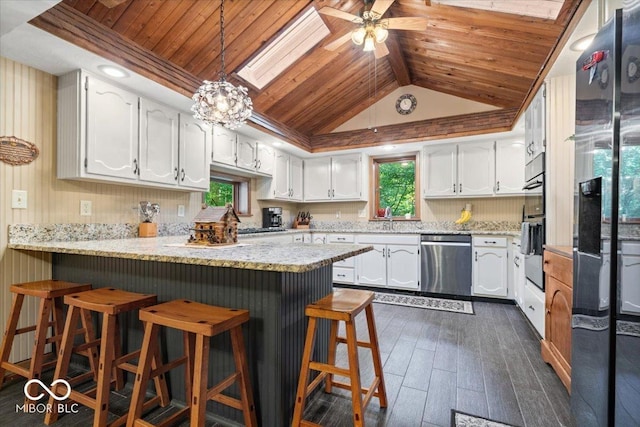 6975 Milhouse Rd, Indianapolis, IN 46221 - kitchen with stainless steel appliances, a peninsula, wood ceiling, white cabinetry, and dark wood-style floors