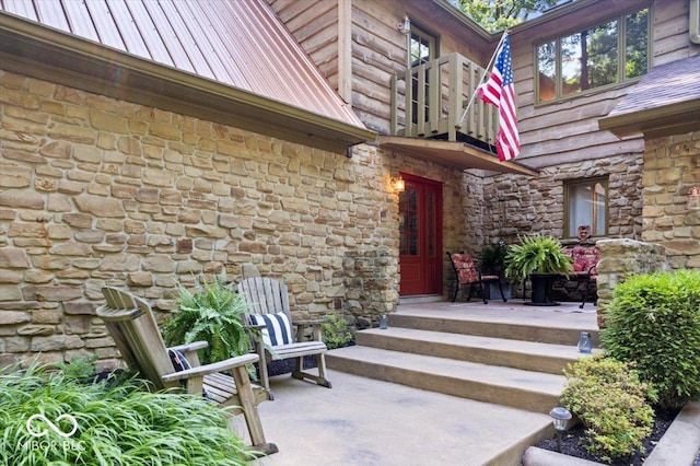 6975 Milhouse Rd, Indianapolis, IN 46221 - doorway to property with stone siding, a balcony, and a metal roof