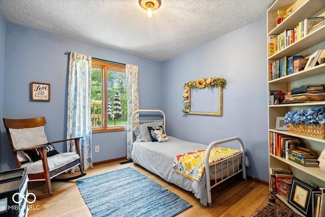 6975 Milhouse Rd, Indianapolis, IN 46221 - bedroom featuring a textured ceiling and wood finished floors
