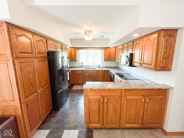 14266 S 125 E, Clinton, IN 47842 - kitchen with stainless steel microwave, freestanding refrigerator, a peninsula, ceiling fan, and brown cabinets