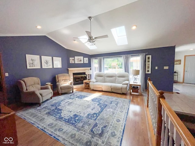 14266 S 125 E, Clinton, IN 47842 - living room featuring lofted ceiling, a ceiling fan, a skylight, a glass covered fireplace, and wood finished floors