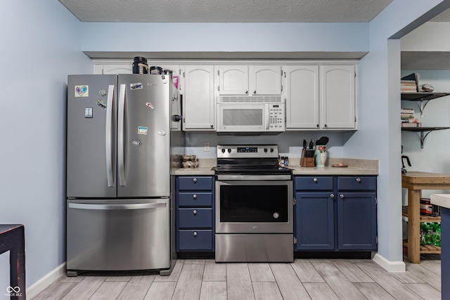 1112 Halifax Ct, Indianapolis, IN 46231 - kitchen featuring appliances with stainless steel finishes, blue cabinets, wood tiled floors, and white cabinets