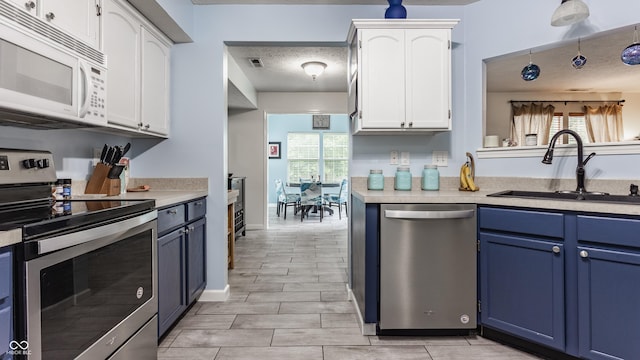 1112 Halifax Ct, Indianapolis, IN 46231 - kitchen featuring appliances with stainless steel finishes, blue cabinets, white cabinetry, and light countertops