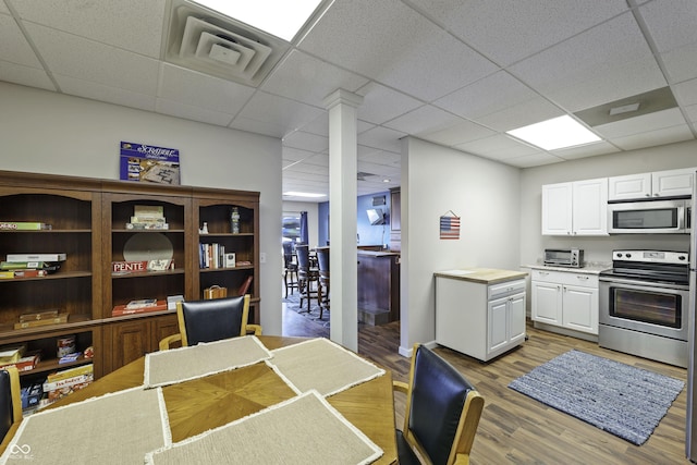 5823 E Sheridan Rd, Monticello, IN 47960 - kitchen with appliances with stainless steel finishes, a drop ceiling, light wood-type flooring, white cabinetry, and light countertops