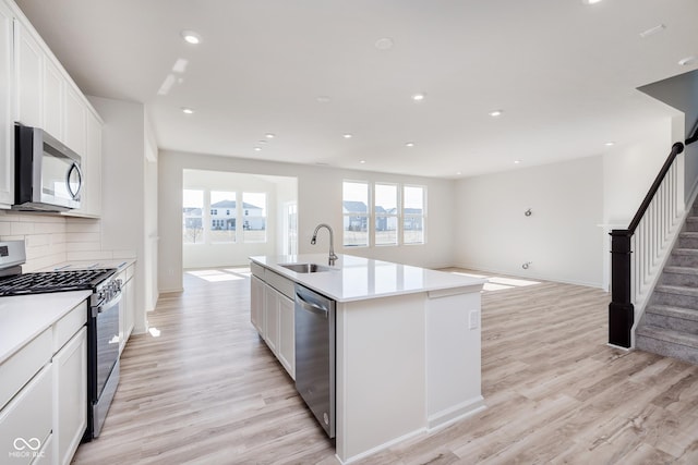 18955 Seaforth Way, Westfield, IN 46074 - kitchen with stainless steel appliances, light wood-style flooring, open floor plan, an island with sink, and recessed lighting