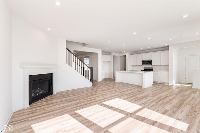18955 Seaforth Way, Westfield, IN 46074 - kitchen featuring stainless steel microwave, light wood-style flooring, white cabinets, and recessed lighting