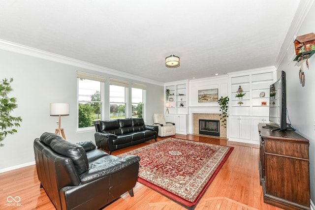 14109 Secretariat Ct, Carmel, IN 46074 - living room with crown molding, a tiled fireplace, light wood-style floors, and built in features