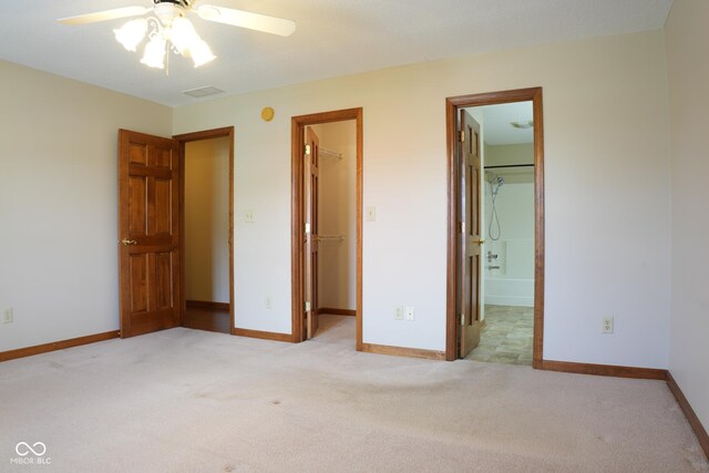413 Blue Spring Dr, Indianapolis, IN 46239 - unfurnished bedroom featuring a walk in closet, light carpet, a closet, and ensuite bathroom