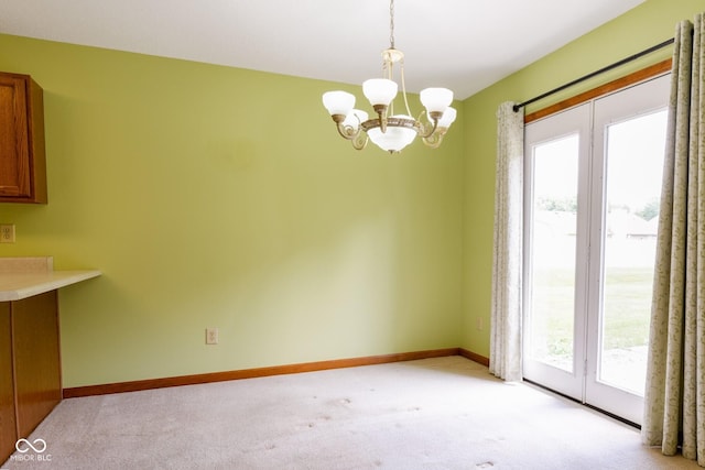 413 Blue Spring Dr, Indianapolis, IN 46239 - unfurnished dining area featuring a chandelier and light colored carpet