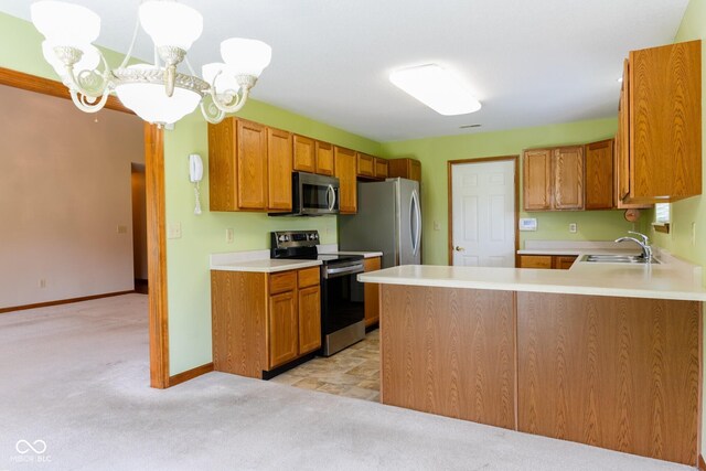 413 Blue Spring Dr, Indianapolis, IN 46239 - kitchen featuring stainless steel appliances, light colored carpet, light countertops, a peninsula, and brown cabinetry