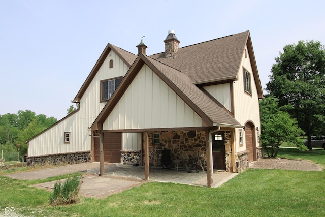 2825 E 216th St, Cicero, IN 46034 - back of house with roof with shingles, a lawn, stone siding, a chimney, and board and batten siding