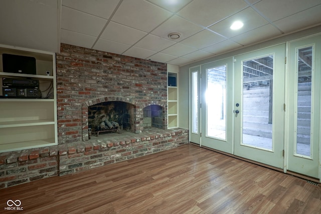 9420 N Kenwood Ave, Indianapolis, IN 46260 - unfurnished living room with french doors, a drop ceiling, wood finished floors, and a fireplace