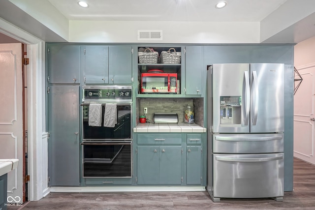9420 N Kenwood Ave, Indianapolis, IN 46260 - kitchen with stainless steel appliances, tile countertops, tasteful backsplash, wood finished floors, and recessed lighting
