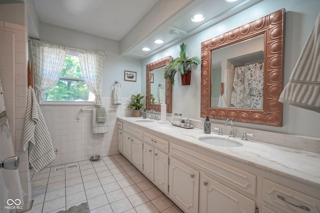 9420 N Kenwood Ave, Indianapolis, IN 46260 - bathroom with tile patterned floors, double vanity, tile walls, and recessed lighting