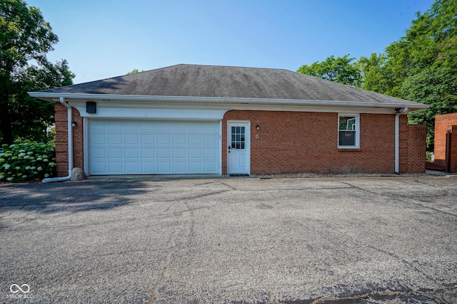 9420 N Kenwood Ave, Indianapolis, IN 46260 - view of property exterior featuring brick siding, asphalt driveway, a shingled roof, and a garage