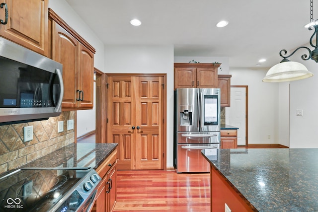 5274 Brooks Bnd, Greenwood, IN 46143 - kitchen with stainless steel appliances, decorative backsplash, dark stone countertops, recessed lighting, and light wood finished floors