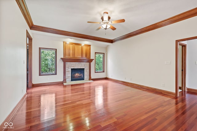 5274 Brooks Bnd, Greenwood, IN 46143 - unfurnished living room featuring ceiling fan, crown molding, light wood-type flooring, and a stone fireplace