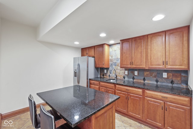 5274 Brooks Bnd, Greenwood, IN 46143 - kitchen featuring stainless steel fridge with ice dispenser, backsplash, recessed lighting, brown cabinetry, and dark stone countertops