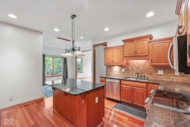 5274 Brooks Bnd, Greenwood, IN 46143 - kitchen with appliances with stainless steel finishes, light wood-style floors, decorative backsplash, a kitchen island, and recessed lighting