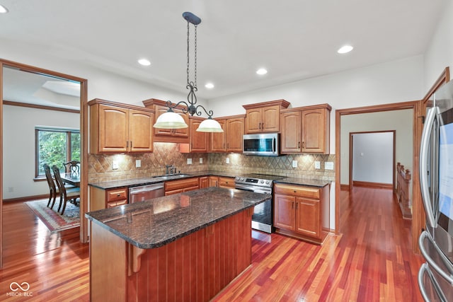 5274 Brooks Bnd, Greenwood, IN 46143 - kitchen featuring appliances with stainless steel finishes, backsplash, light wood-style flooring, hanging light fixtures, and recessed lighting