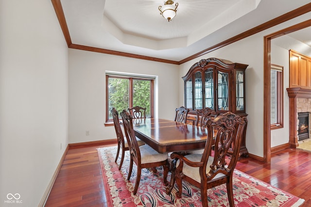 5274 Brooks Bnd, Greenwood, IN 46143 - dining area with a tray ceiling, wood-type flooring, a glass covered fireplace, and crown molding