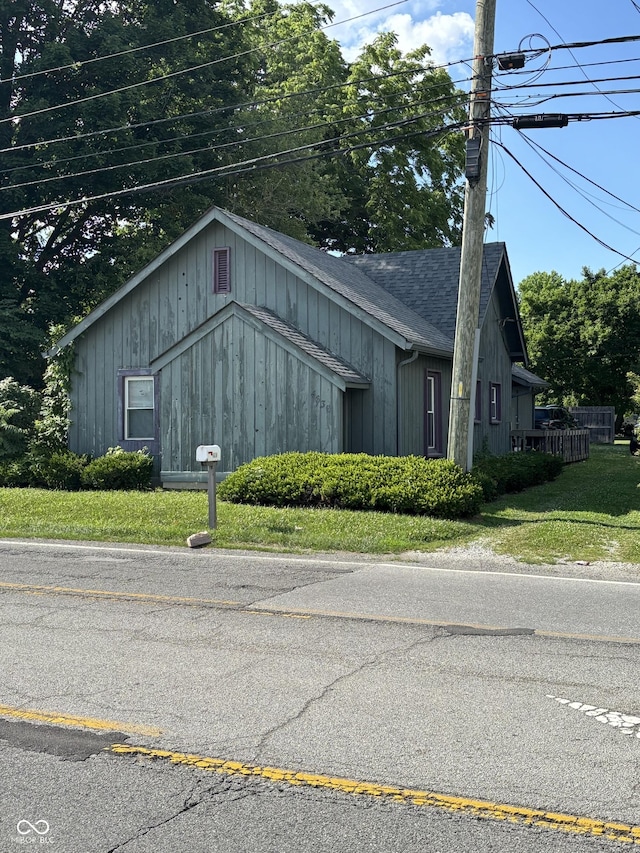 4630 W 71st St, Indianapolis, IN 46268 - view of property exterior featuring a shingled roof, a lawn, and board and batten siding