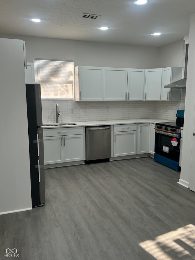 2127 Haines Ave, Indianapolis, IN 46221 - kitchen featuring appliances with stainless steel finishes, backsplash, wood finished floors, and recessed lighting