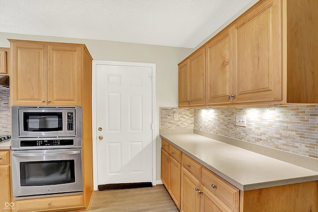 8038 Sydney Ln, Avon, IN 46123 - kitchen featuring stainless steel appliances, light wood-style flooring, decorative backsplash, and light countertops