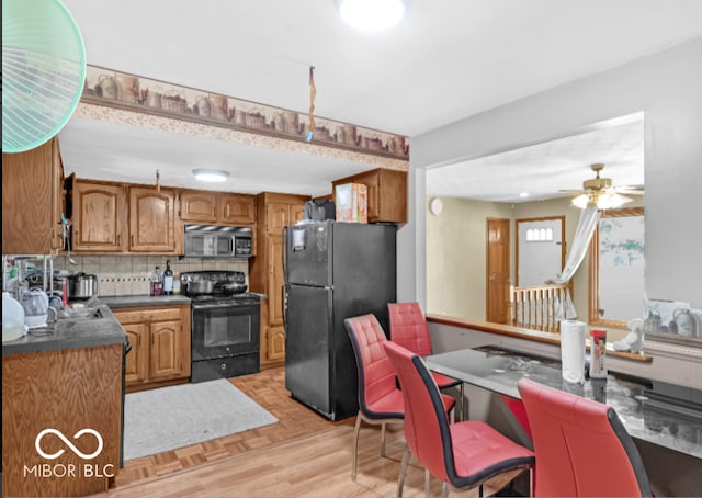 8217 S Talbott Ave, Indianapolis, IN 46227 - kitchen with black appliances, brown cabinets, a ceiling fan, dark countertops, and decorative backsplash