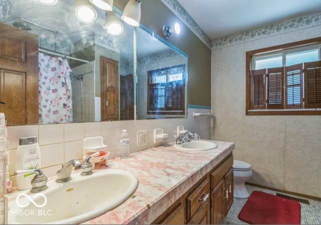8217 S Talbott Ave, Indianapolis, IN 46227 - full bath featuring healthy amount of natural light, curtained shower, double vanity, tasteful backsplash, and tile walls