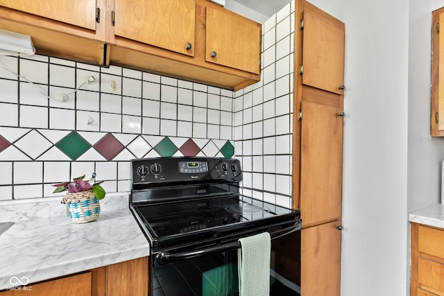1020 N Ritter Ave, Indianapolis, IN 46219 - kitchen featuring electric range, decorative backsplash, and brown cabinets