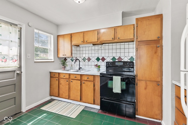 1020 N Ritter Ave, Indianapolis, IN 46219 - kitchen with black range with electric cooktop, tasteful backsplash, light countertops, brown cabinetry, and dark tile patterned floors