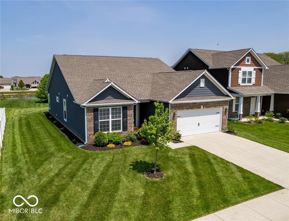 8820 Hemingway Dr, Indianapolis, IN 46239 - view of front of property featuring brick siding, a front lawn, concrete driveway, and an attached garage