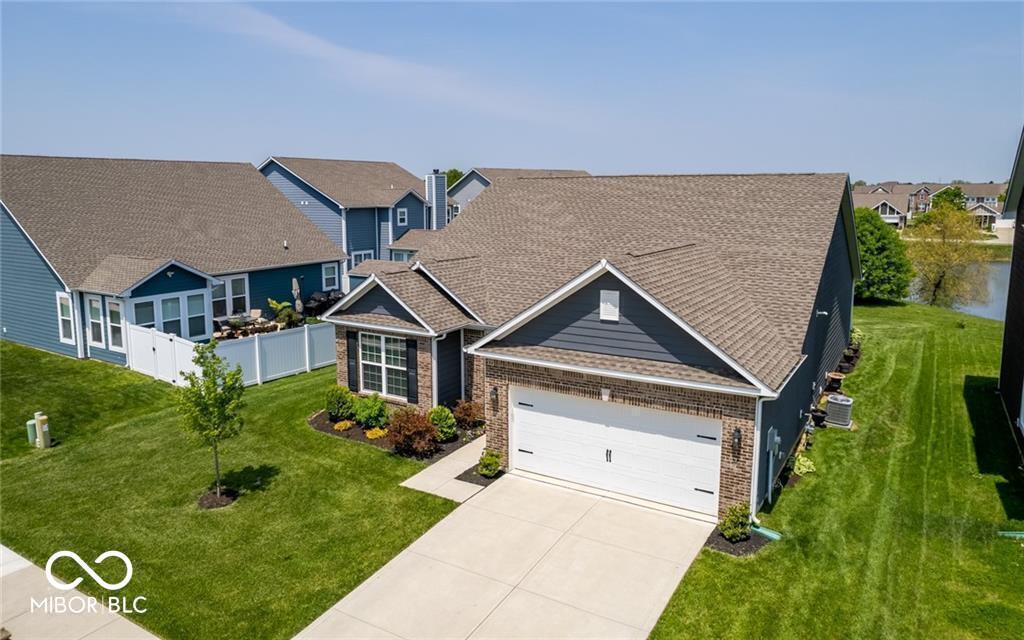 8820 Hemingway Dr, Indianapolis, IN 46239 - view of front of house featuring driveway, brick siding, an attached garage, and a residential view